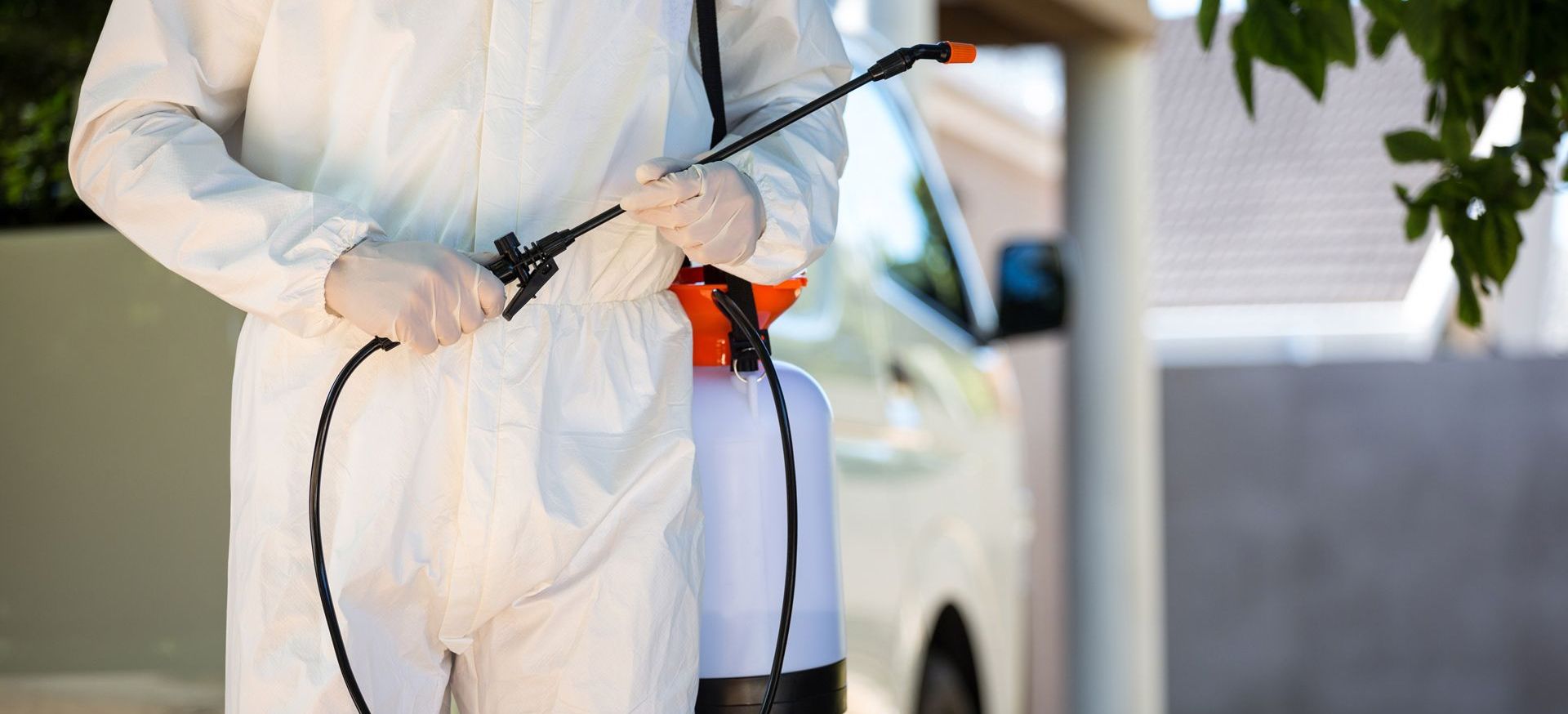 A man in a protective suit is spraying something with a sprayer | Texas | Tom Samples Pest Control